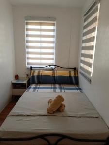 ein ausgestopftes Tier auf einem Bett im Schlafzimmer in der Unterkunft Niana’s Place 2BR w Garden, Internet, Netflix in Legazpi