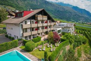 uma vista aérea de uma casa com piscina e montanhas em Residence Sardis em Castelbello