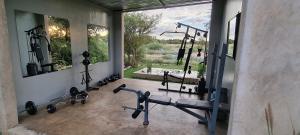 una sala de fitness con un gimnasio con una gran ventana en Hackberry House Black Thorn Cottage, Off Grid en Khemsbok