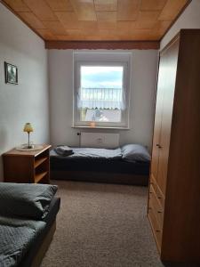 een slaapkamer met een bed en een raam bij Gästewohnung KL. WZL 33_7 