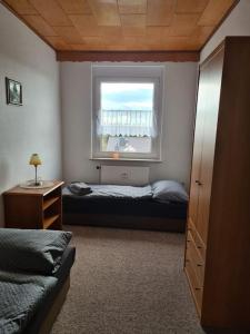 a bedroom with a bed and a window at Gästewohnung KL. WZL 33_7 in Klein Wanzleben