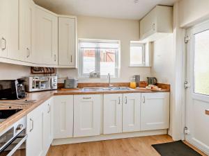 a kitchen with white cabinets and a sink at 2 Bed in Paignton 92055 in Paignton