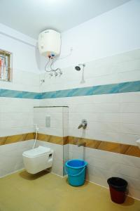 a bathroom with a toilet and a blue bucket at LEE PARADISE INN in Bangalore