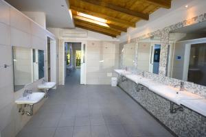 a bathroom with three sinks and a row of mirrors at Centro Vacanze San Marino in San Marino +60 photos