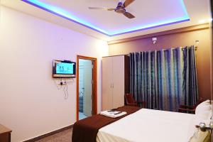 1 dormitorio con 1 cama y TV en el techo en LEE PARADISE INN en Bangalore