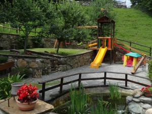 a park with a playground with a slide and a pond at Agriturismo Barcola in Grandola ed Uniti