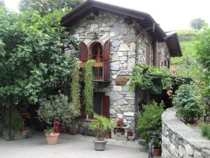 a stone house with a window and plants at Agriturismo Barcola in Grandola ed Uniti