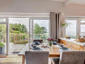 Un comedor con una mesa y un gran ventanal. en 2 Bed in Aberdovey 91946, en Aberdyfi