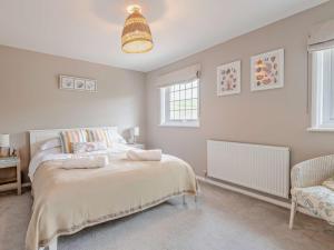 a bedroom with a bed and a chair in it at 3 Bed in West Lulworth 92106 in West Lulworth