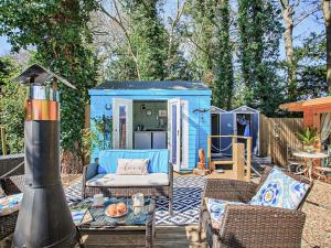 a blue shed with a table and chairs in a yard at 1 Bed in Llanrhaeadr 91890 in Llanrhaiadr