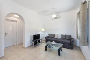 a living room with a couch and a tv at Ann-Margo House in Fira