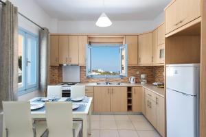a kitchen with wooden cabinets and a window at Ann-Margo House in Fira