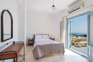 a bedroom with a bed and a balcony at Ann-Margo House in Fira