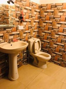 a bathroom with a toilet and a sink at NEWCINNAMONVILLA in Habaraduwa