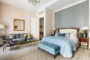 um quarto com uma cama, uma cadeira e um sofá em Hôtel San Régis em Paris