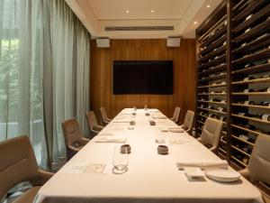 a conference room with a long table and a television at Hotel Mvsa+Michelin 2 Starred Molino de Urdàniz in Taipei