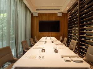 una sala de conferencias con mesa larga y TV en Hotel Mvsa+Michelin 2 Starred Molino de Urdàniz, en Taipéi