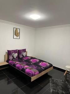 Bett in einem Zimmer mit lila Bettwäsche und Kissen in der Unterkunft Super Appartement T2 Luxe 