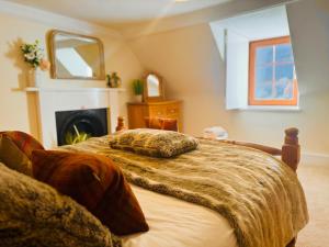a bedroom with a bed and a fireplace and a mirror at Rosemount Cottage TWO - Highland Cottage in Garve