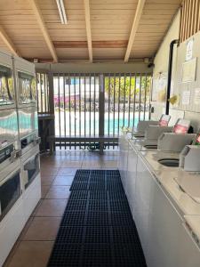 a kitchen with white counter tops and windows at Your Slice of Paradise in Kona in Kailua-Kona