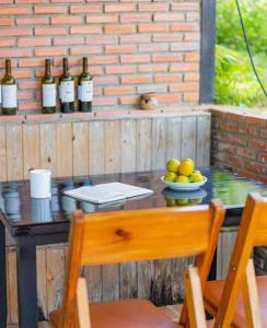 a table with a bowl of fruit and bottles of wine at Scent Bungalow Hotel in Da Lat