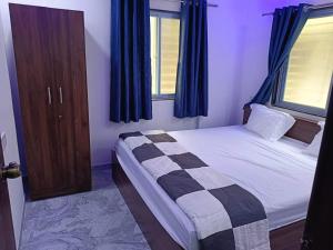 a small bedroom with a bed and a window at Soumil 102 in Chinchwad