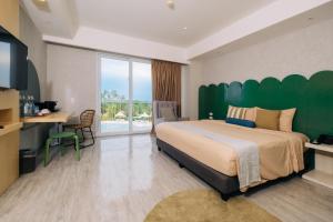 a bedroom with a large bed with a green headboard at Solea Mactan Resort in Mactan