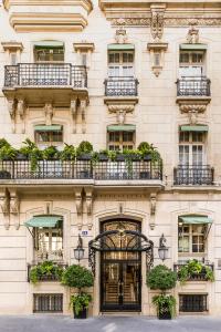 un bâtiment avec des plantes en pot à l'avant dans l'établissement Hôtel San Régis, à Paris