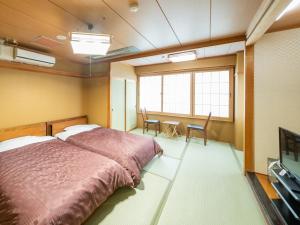 a bedroom with a bed and a table with chairs at Sumiyoshiya in Nagaoka