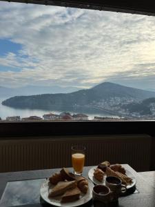a table with a plate of food and a glass of orange juice at sunlight loft in Kastoria
