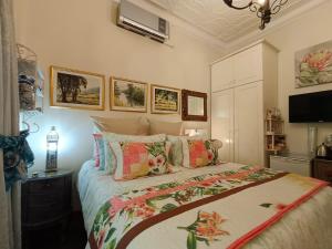 1 dormitorio con 1 cama grande y almohadas coloridas en 79 On Ridge, en Pietermaritzburg