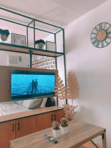 a living room with a large flat screen tv at Black & Bold - 1BR Condo 50mbpsWIFI near SM Marilao in Marilao