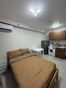 a bedroom with a large bed and a kitchen at Ross' Cosy Corner in Lapu Lapu City