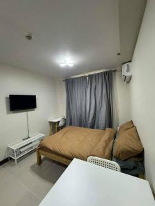 a small room with a bed and a television at Ross' Cosy Corner in Lapu Lapu City