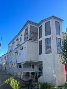 un gran edificio blanco con una mesa de picnic delante de él en Prince house, en Kobuleti