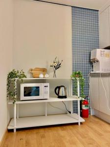 a kitchen with a microwave on a white shelf at Raon house in Suwon