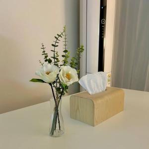 a vase with white flowers and a box on a table at Raon house in Suwon
