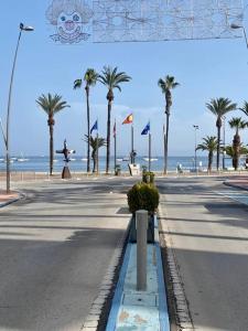 uma rua vazia com palmeiras e o oceano em Casa Marisa In Santiago De la Ribera.Murcia em Santiago de la Ribera