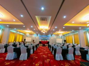 um salão de banquetes com filas de cadeiras e um palco em Sindoro Hotel Cilacap By Conary em Cilacap