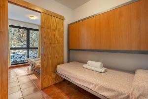 um pequeno quarto com uma cama e uma janela em Monte Gorbea 7 J em Sierra Nevada