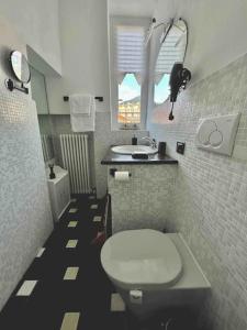 La salle de bains est pourvue de toilettes blanches et d'un lavabo. dans l'établissement Casa Oh! Rapallo, à Rapallo