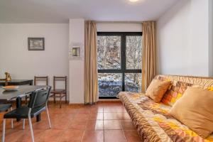 uma sala de estar com um sofá e uma mesa em Monte Gorbea 7 J em Sierra Nevada