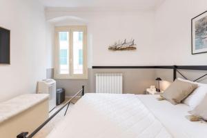 - une chambre blanche avec un grand lit et une fenêtre dans l'établissement Casa Oh! Rapallo, à Rapallo