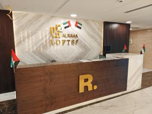 a reception desk in a lobby with arialler luthiers sign at Al Raha Glamour 3BR with Beach Access in Abu Dhabi