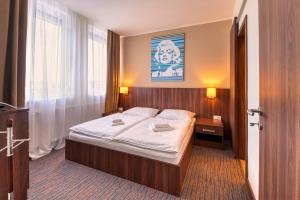 a bedroom with a large bed with white sheets at Congress Hotel Centrum in Košice