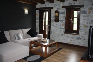 een woonkamer met een witte bank en een salontafel bij Hotel Rural El Reundu in Campomanes