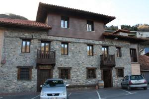 un edificio con dos coches estacionados frente a él en Hotel Rural El Reundu, en Campomanes