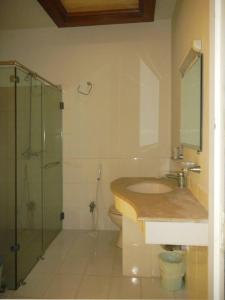 ein Bad mit einem Waschbecken und einer Glasdusche in der Unterkunft silk.hotel in Faisalabad