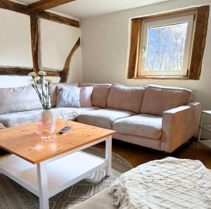 a living room with a couch and a table at Fachwerkwohnung im Weserbergland in Aerzen