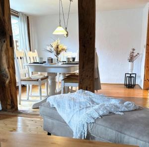 a living room with a table and a couch at Fachwerkwohnung im Weserbergland in Aerzen
